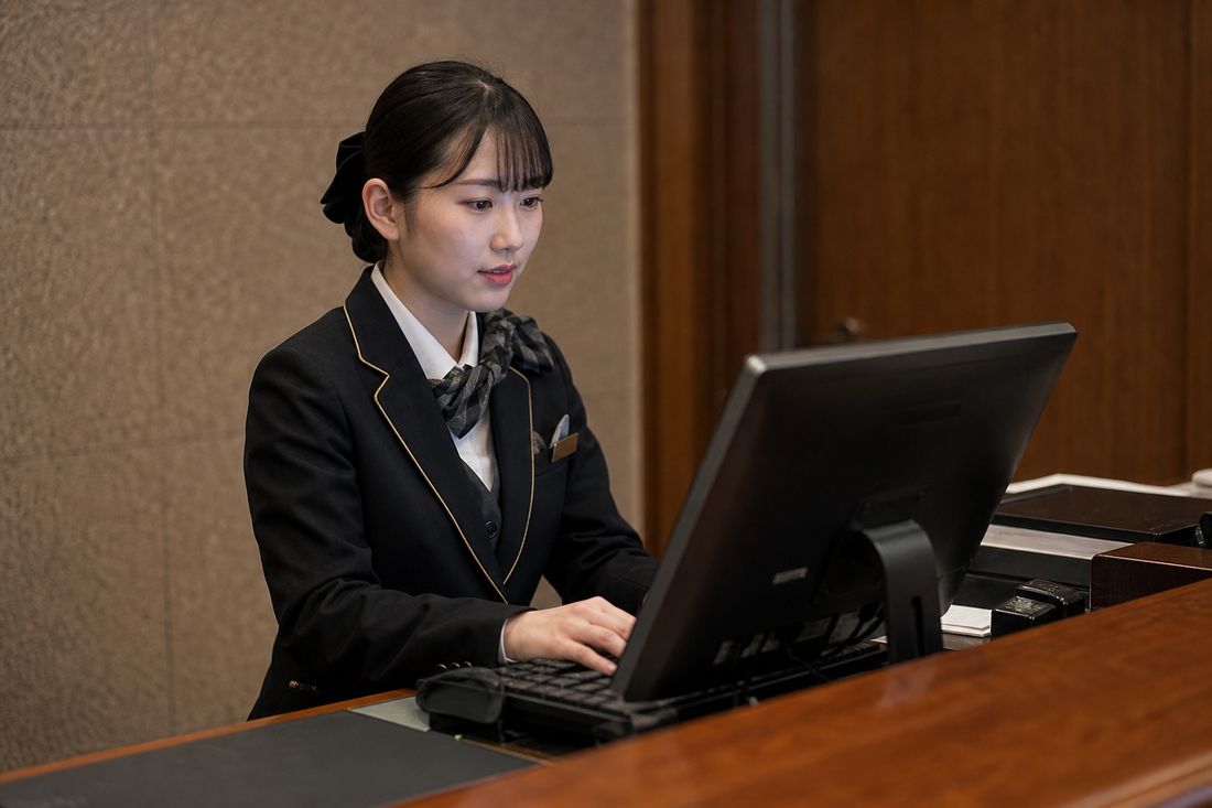 フロントでPMSを操作するスタッフ