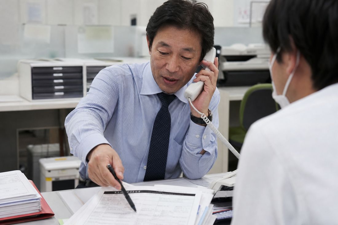 申込書の記載内容を確認する担当者