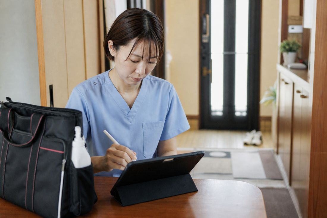 訪問記録を見ながら報告書を作成する事務担当